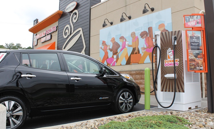 A car pulls up to a charging station outside Dunkin' Donuts. Image courtesy of Dunkin' Donuts.