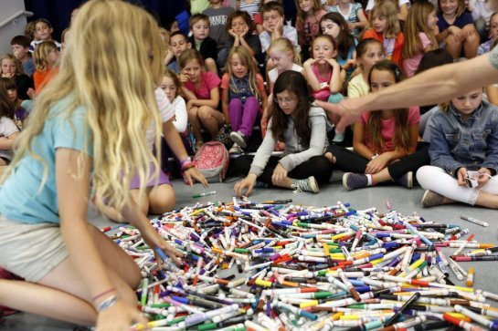 Third grade student Hannah Knudsen, left, helps Land Wilson spread out 33 pounds of Crayola markers for a group picture at the Sun Valley Elementary School in San Rafael, Calif. on June 6, 2013. The students in Mr. Land's Kids Who Care petitioned Crayola to recycle used markers with over 92,000 signatures.
